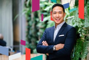 Professional in business attire with patterned background.