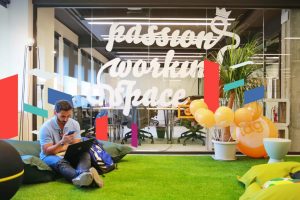 Man working on a laptop in a modern SPC Free Zone office with vibrant decor.
