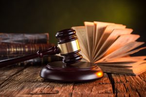 Gavel on table with open law book